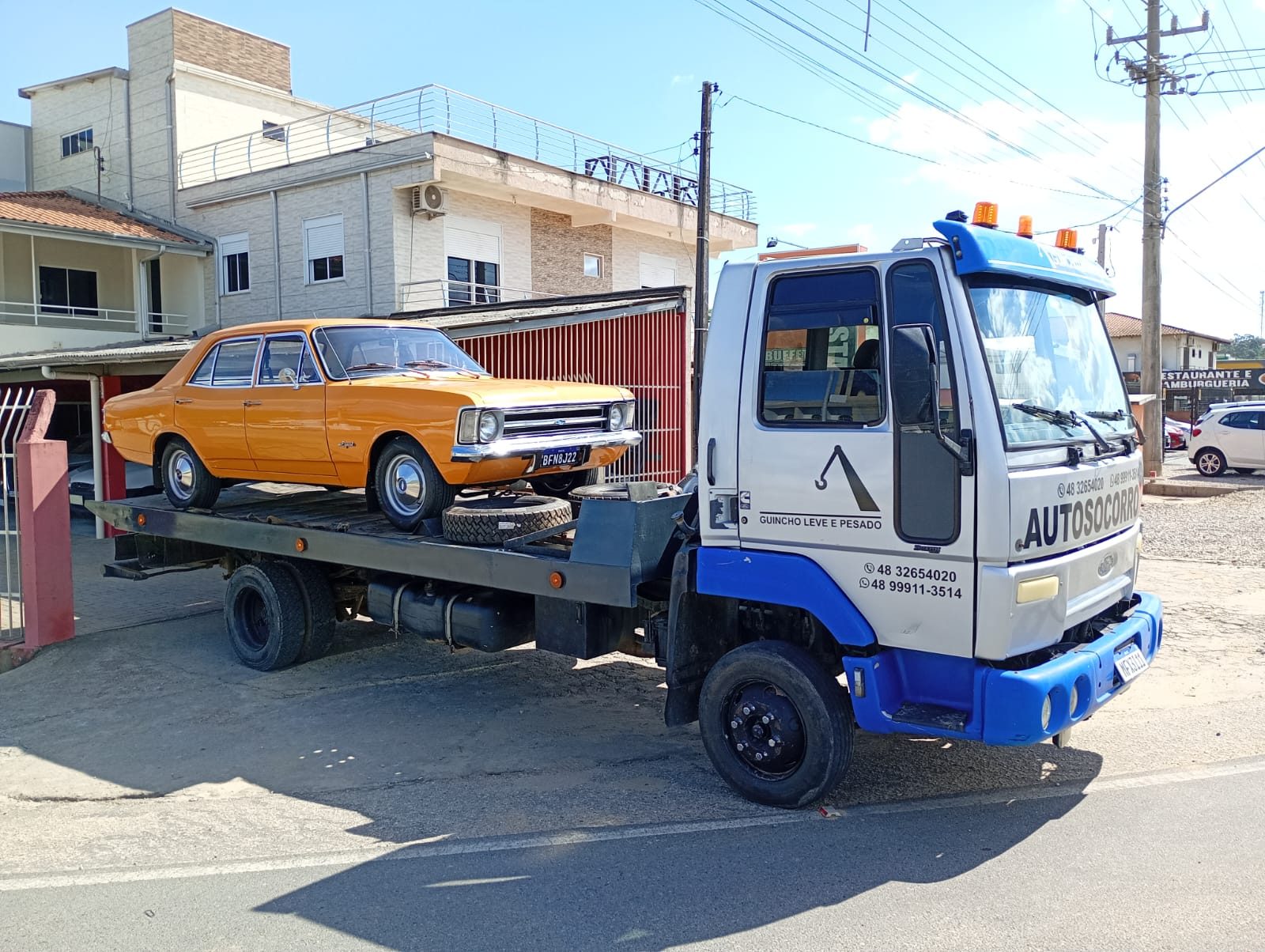 Guincho de plataforma transportando um Chevrolet Opala restaurado